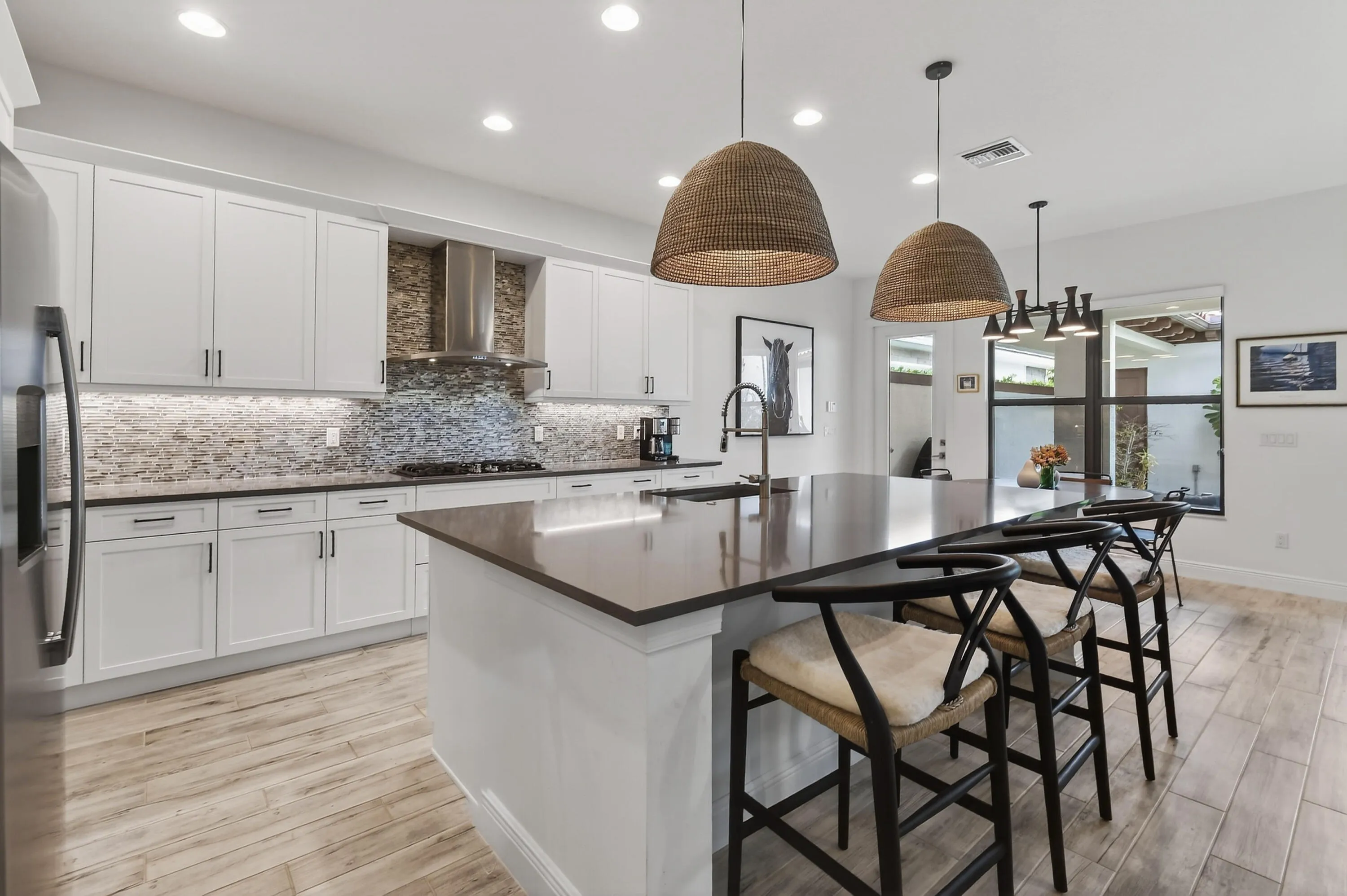 Kitchen features natural gas cooking and exterior-vented stainless steel chimney hood