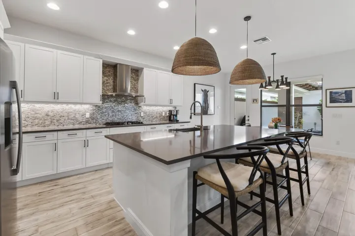 Kitchen features natural gas cooking and exterior-vented stainless steel chimney hood