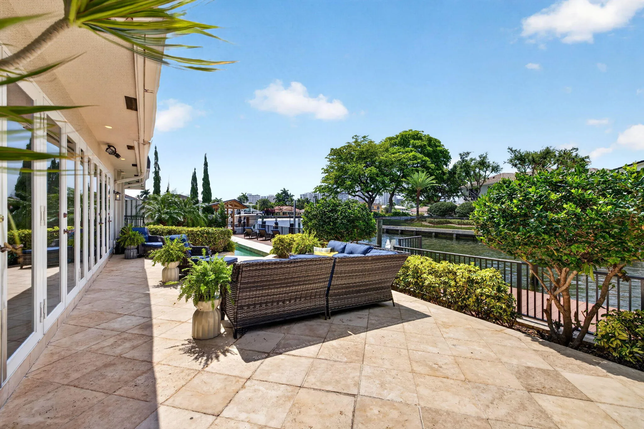 The terrace offers a comfortable outdoor lounge area overlooking the canal and tropical landscaping.