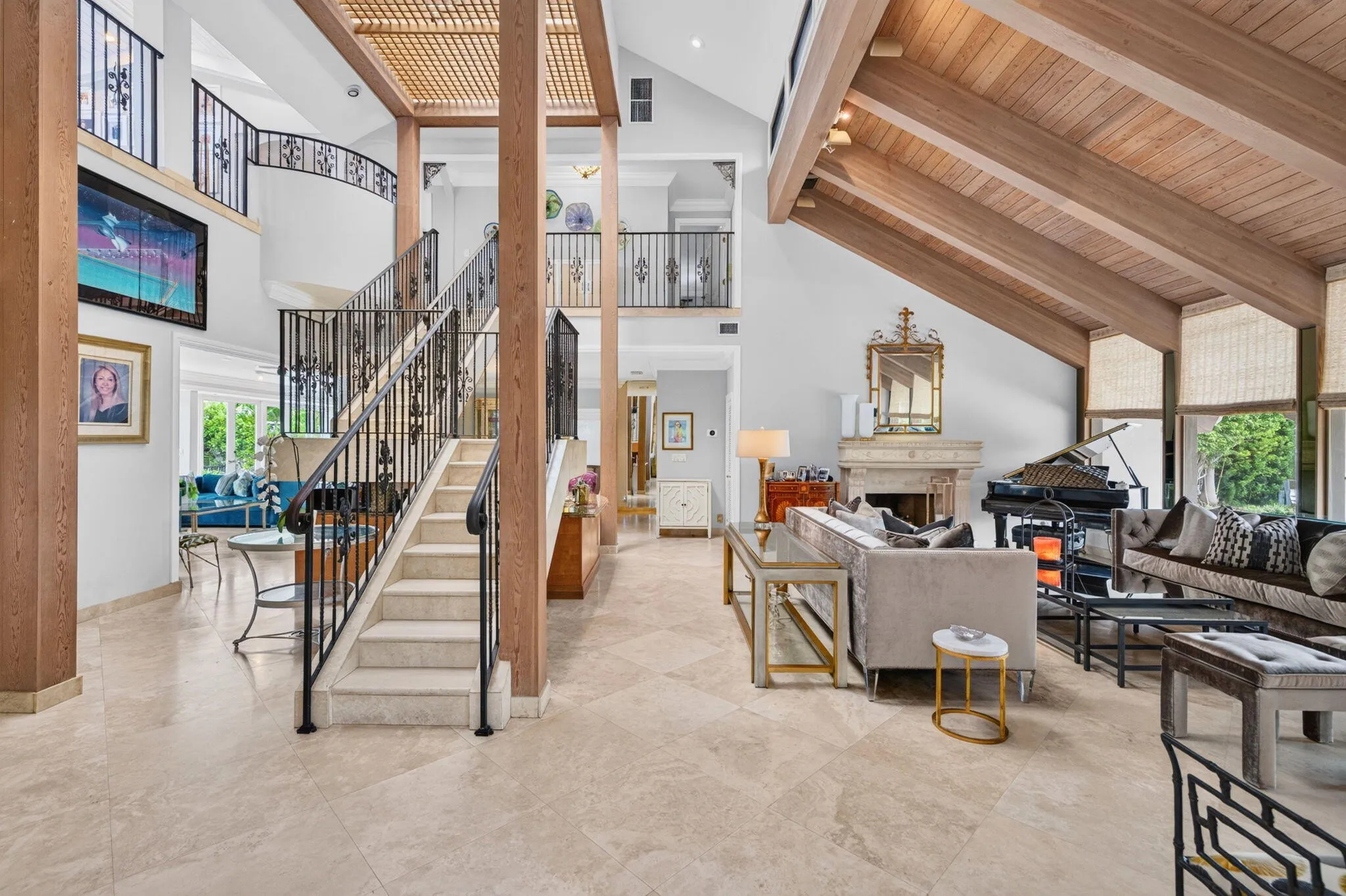 A double-height living room creates an impressive first impression with volume, natural light, and a sculptural staircase.