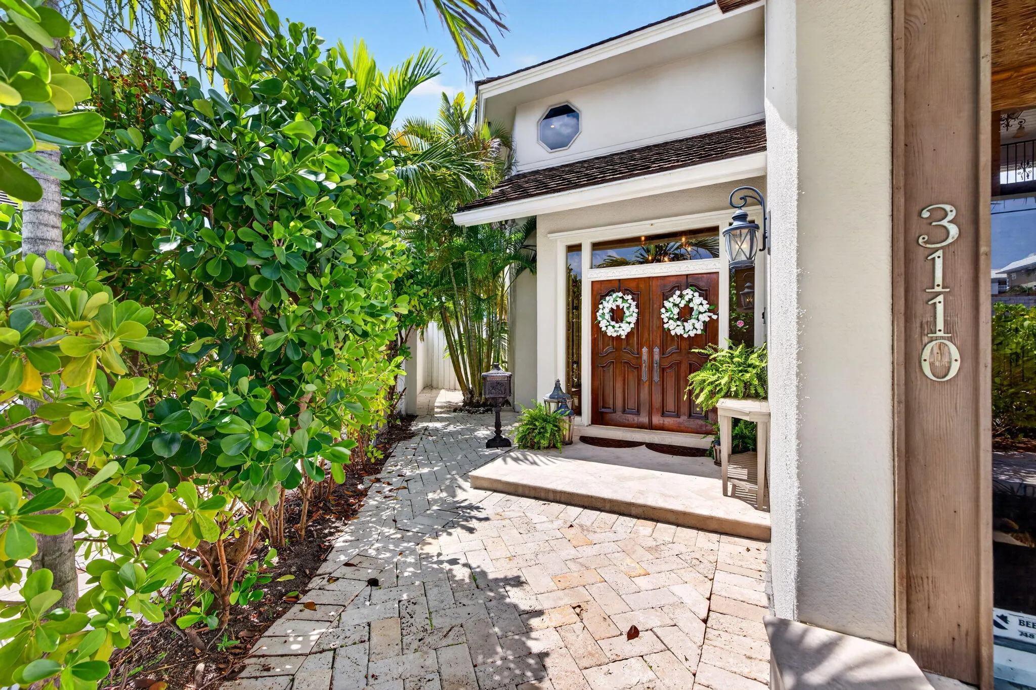 A gracious front entry sets the tone with lush landscaping, double doors, and a refined arrival sequence.
