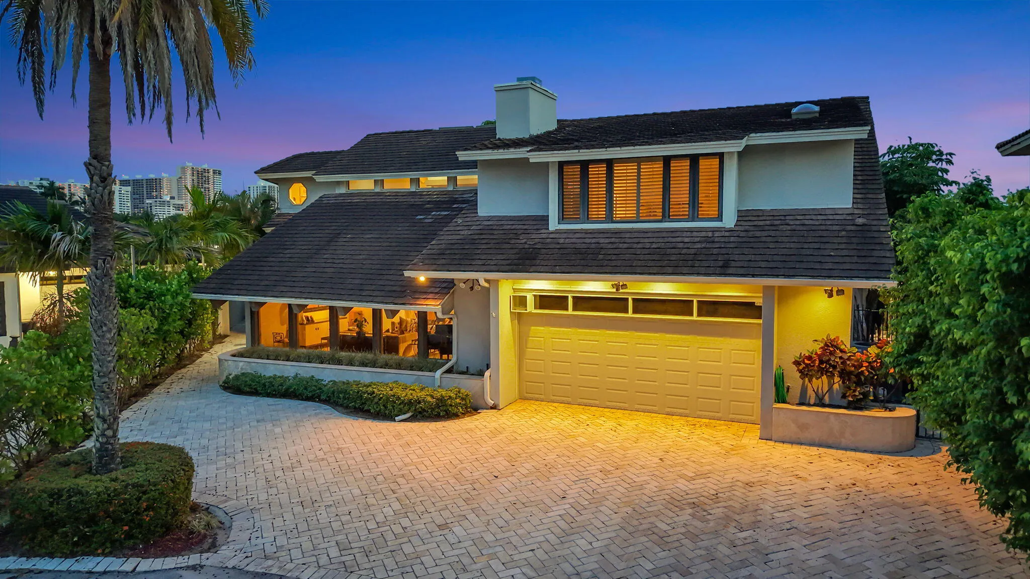 Elegant twilight curb appeal introduces the residence with warm exterior lighting and a polished waterfront-home presence.