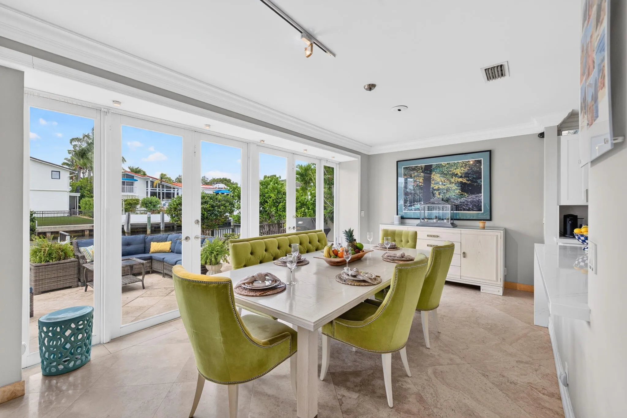 The breakfast area captures canal views through large glass doors, blending everyday dining with the waterfront lifestyle.