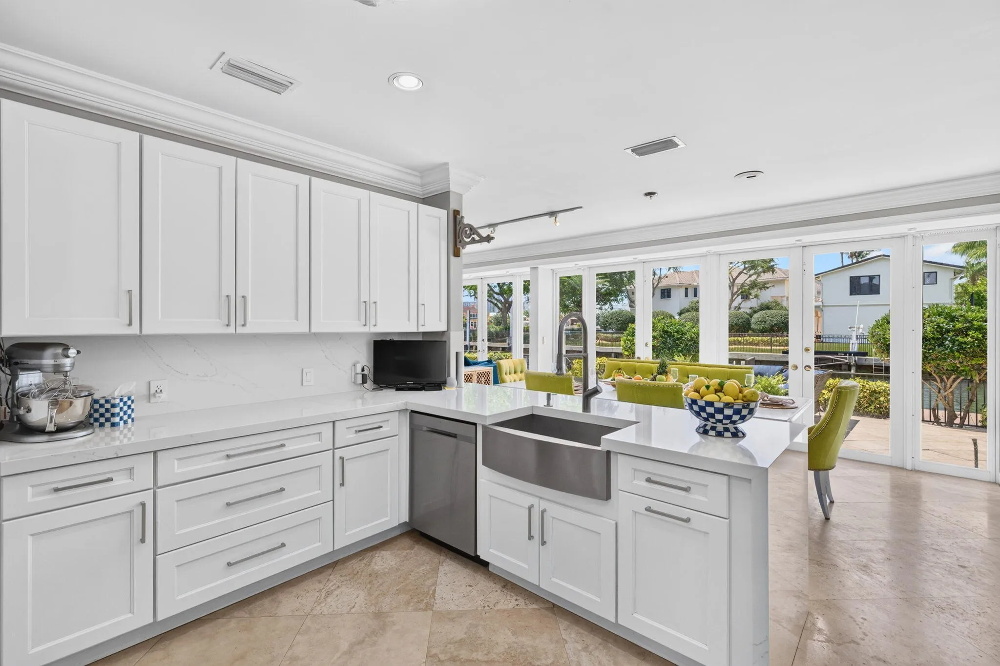 Glass doors connect the kitchen to the terrace, keeping the waterfront and outdoor living areas in view.