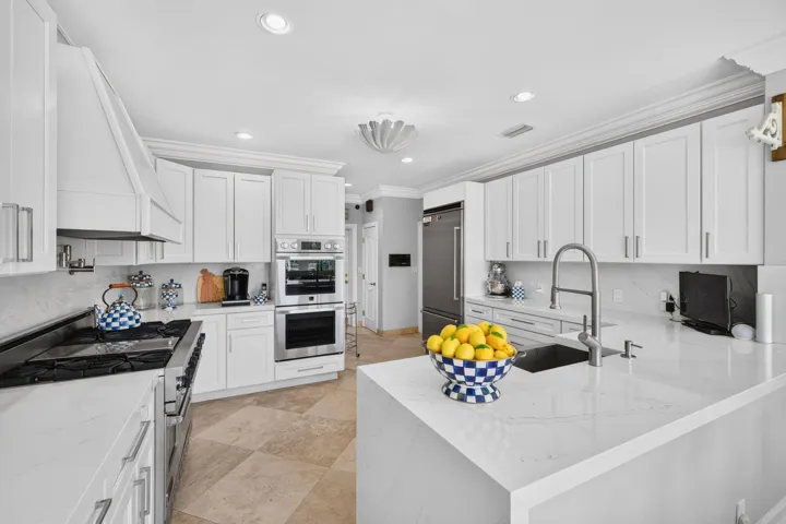 A central island anchors the kitchen with generous prep space, clean finishes, and strong functionality.