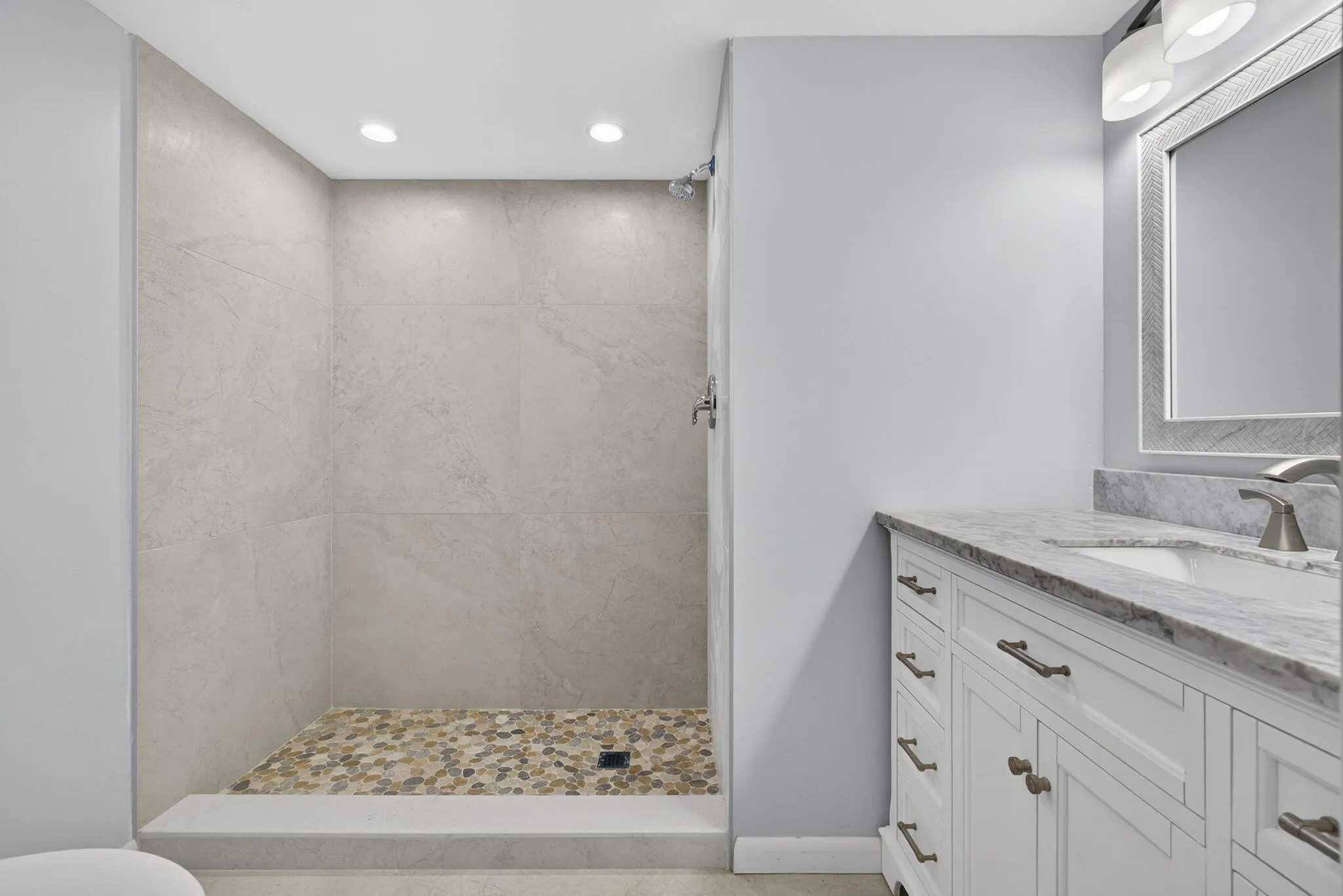 Guest bathroom with new vanity, mirror, lighting, toilet and tiled shower