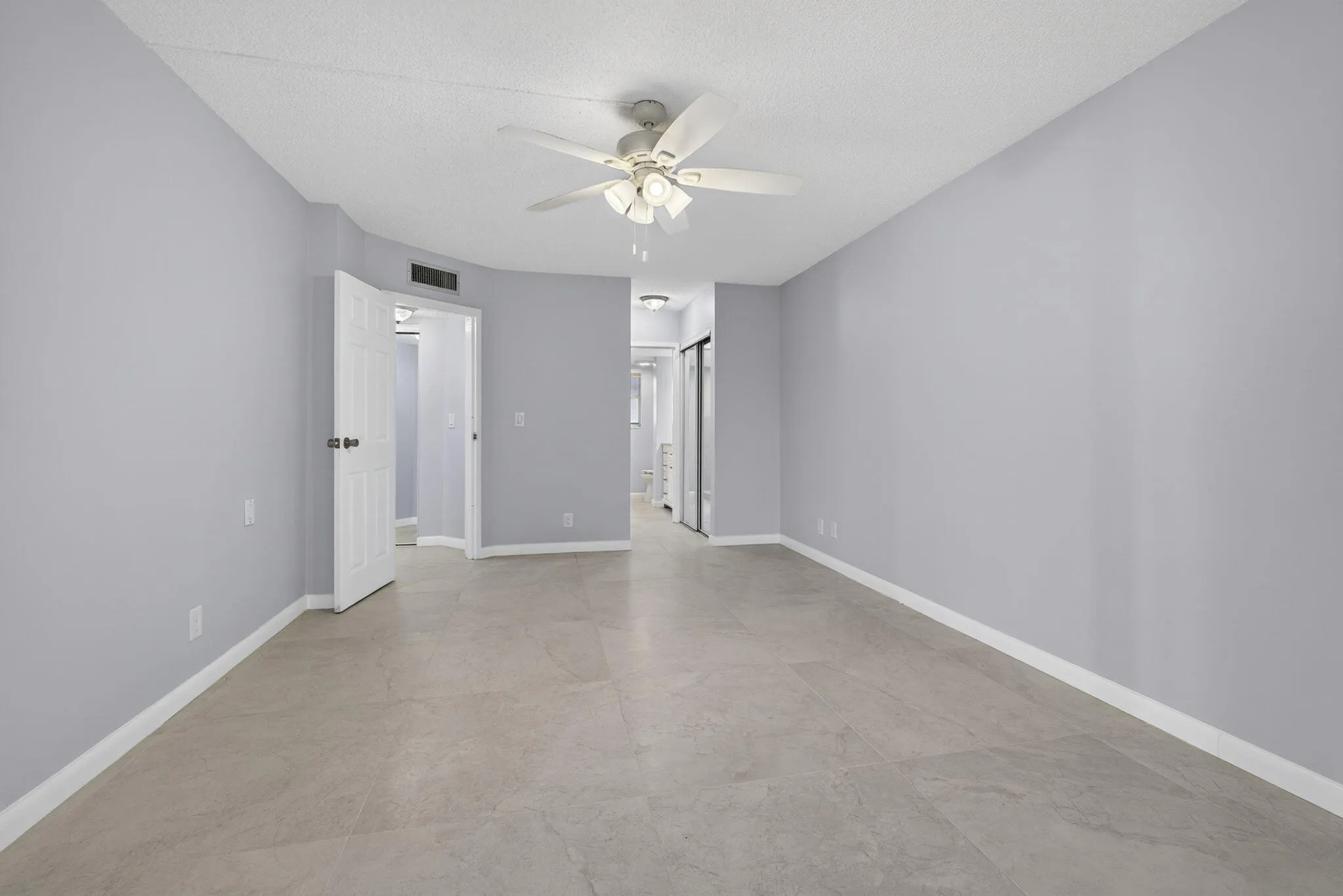 View of master bedroom from balcony area showing bathroom and entry area