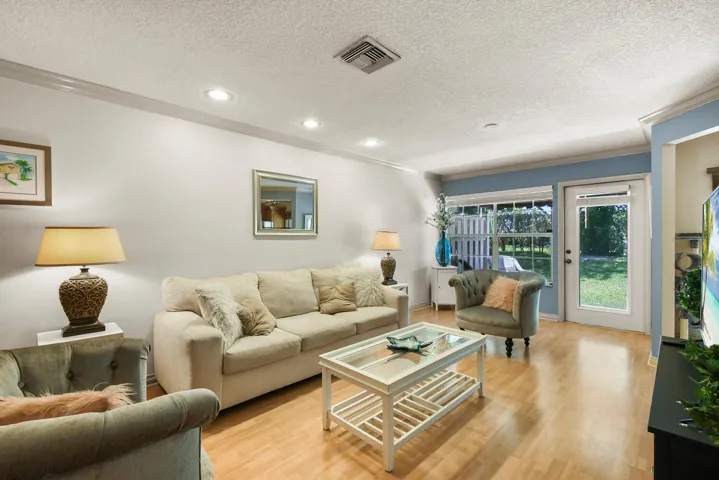 Spacious family room filled with natural light, featuring recessed lighting, generous living space, and large windows overlooking the private backyard. The inviting layout flows seamlessly to the patio and outdoor living area, creating the perfect setting for relaxing or entertaining.