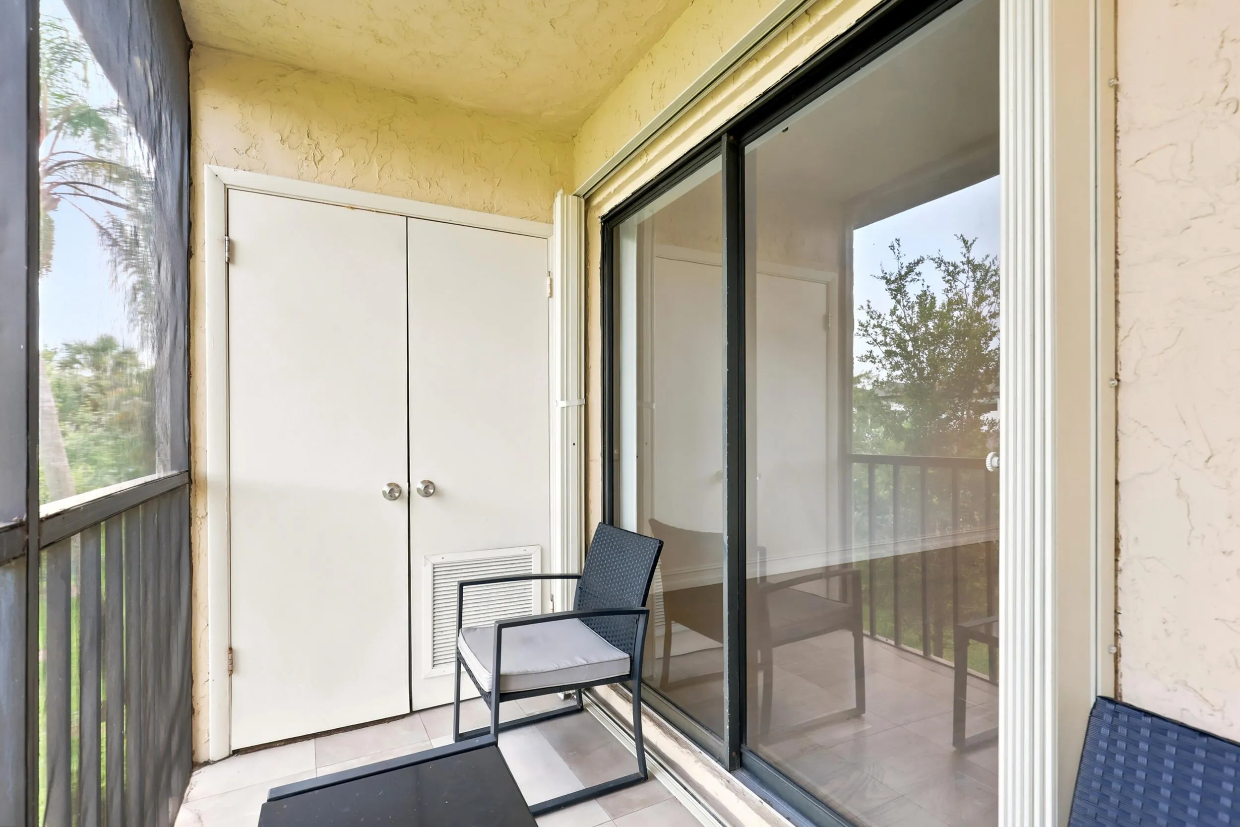 Enjoy your own private outdoor retreat from this screened balcony overlooking lush green space and mature tropical landscaping. Accessible directly from the living area, this inviting space is perfect for morning coffee, evening relaxation, or simply enjoying the peaceful surroundings and year-round South Florida weather. The screened enclosure provides added comfort while preserving the tranquil garden views below.