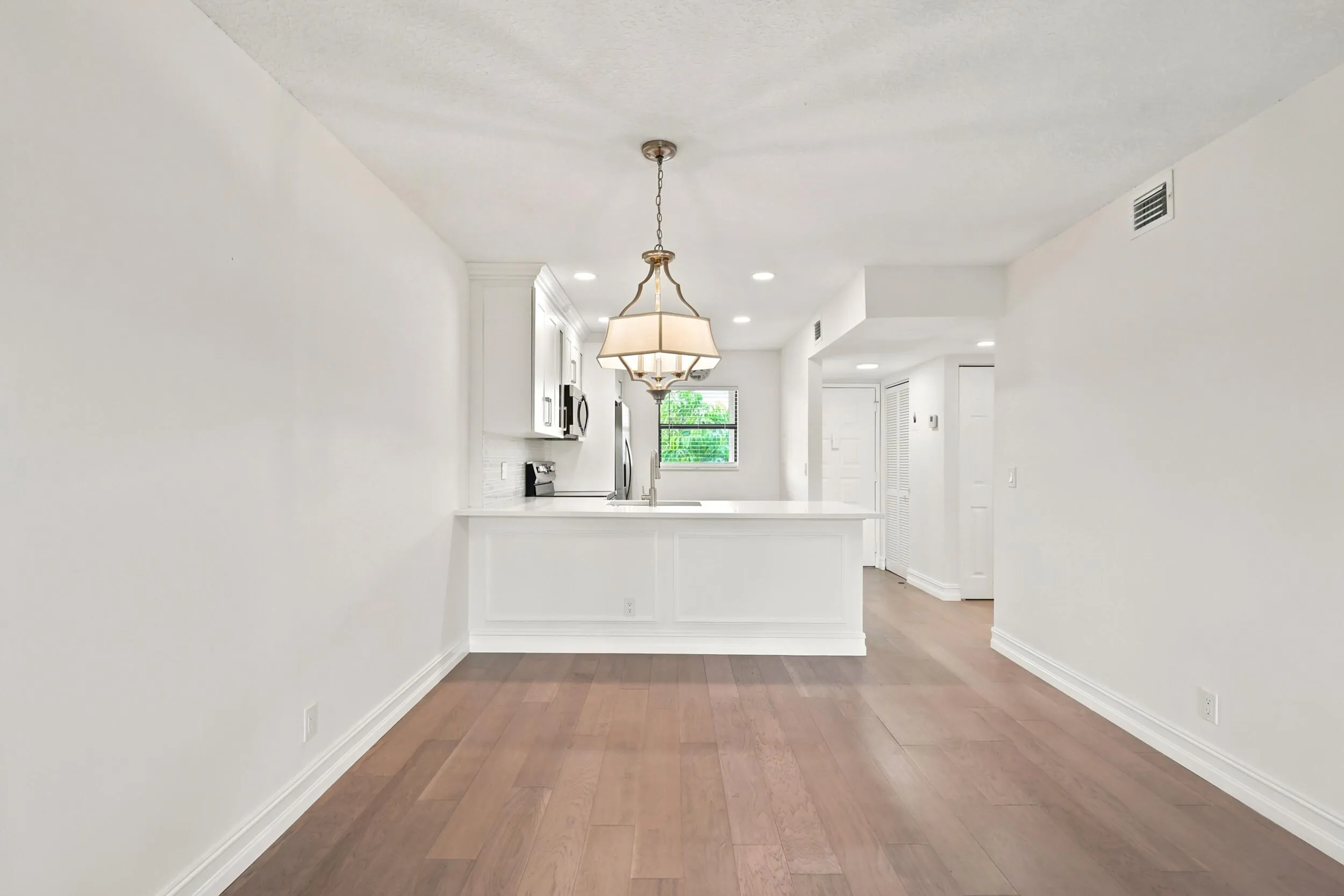 The spacious living area offers an open and versatile layout designed for comfortable everyday living and entertaining. Updated flooring flows throughout the space, while large sliding glass doors fill the room with natural light and provide seamless access to the private screened balcony. The open-concept design connects effortlessly to the kitchen and dining areas, creating a bright and inviting atmosphere throughout the home.