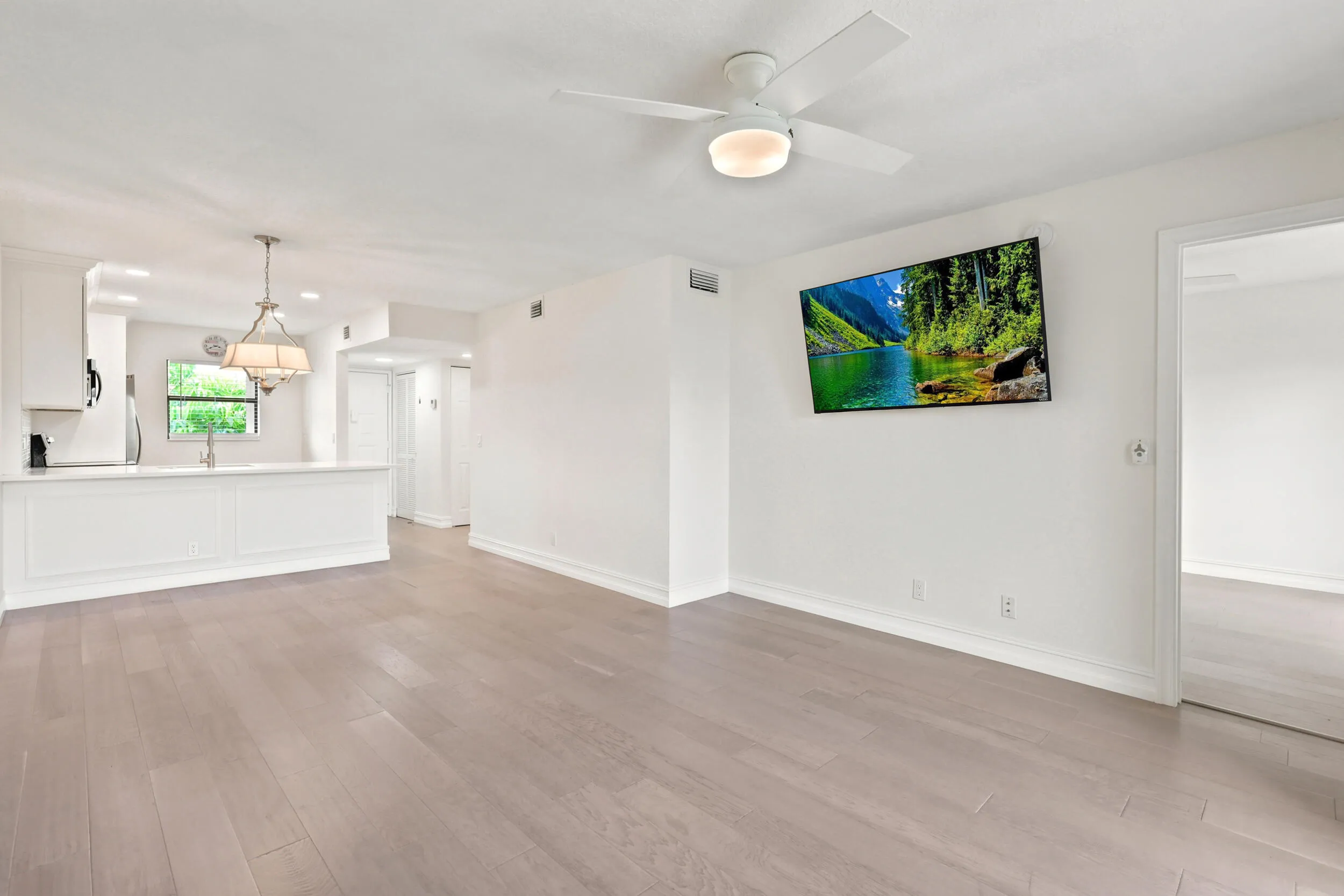 The spacious living area offers an open and versatile layout designed for comfortable everyday living and entertaining. Updated flooring flows throughout the space, while large sliding glass doors fill the room with natural light and provide seamless access to the private screened balcony. The open-concept design connects effortlessly to the kitchen and dining areas, creating a bright and inviting atmosphere throughout the home.