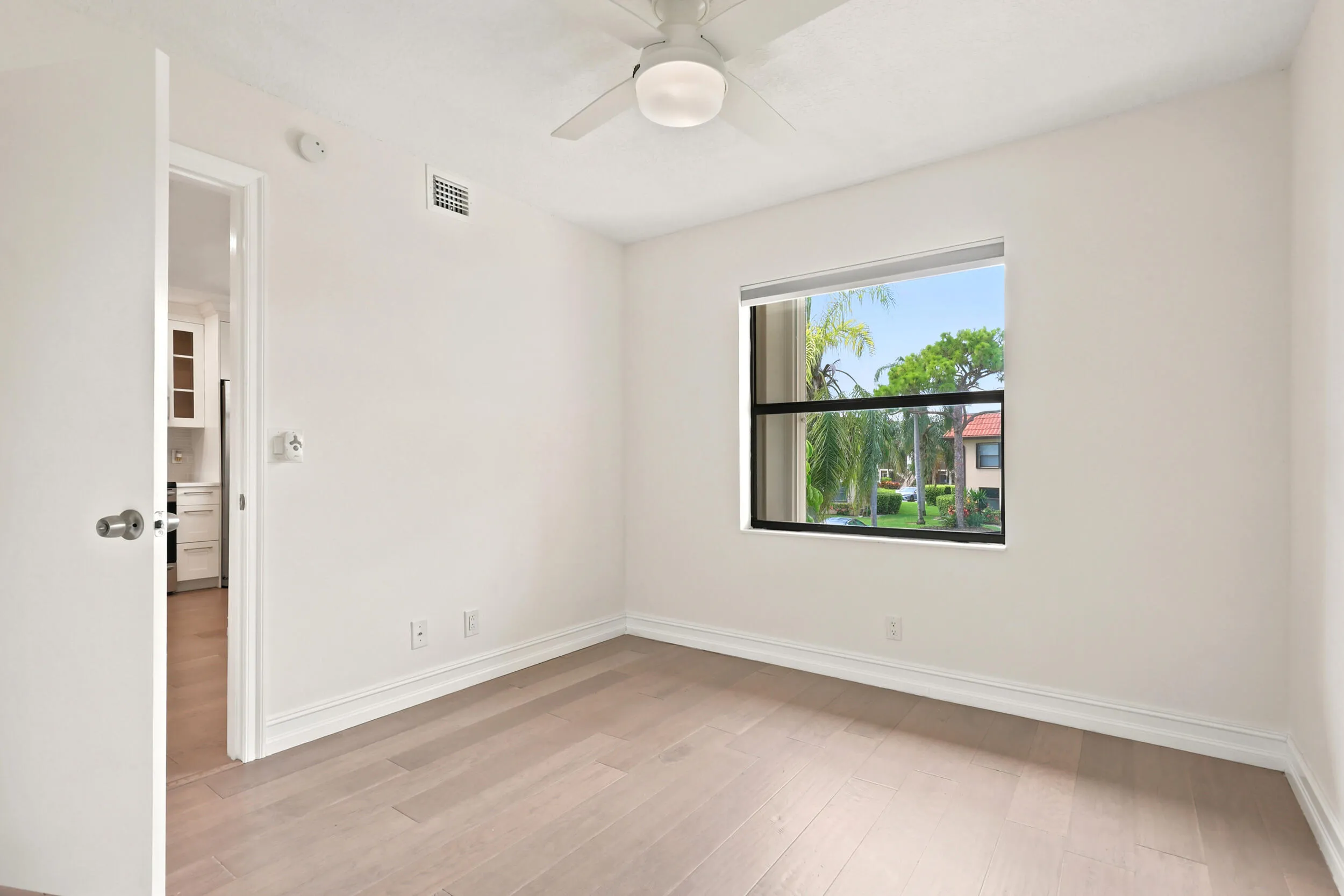 Bright and comfortable, the guest bedroom features updated flooring, generous closet space, and a large window that brings in plenty of natural light while overlooking the community's beautifully maintained grounds. The versatile layout is ideal for guests, a home office, or additional living space, offering both comfort and flexibility.