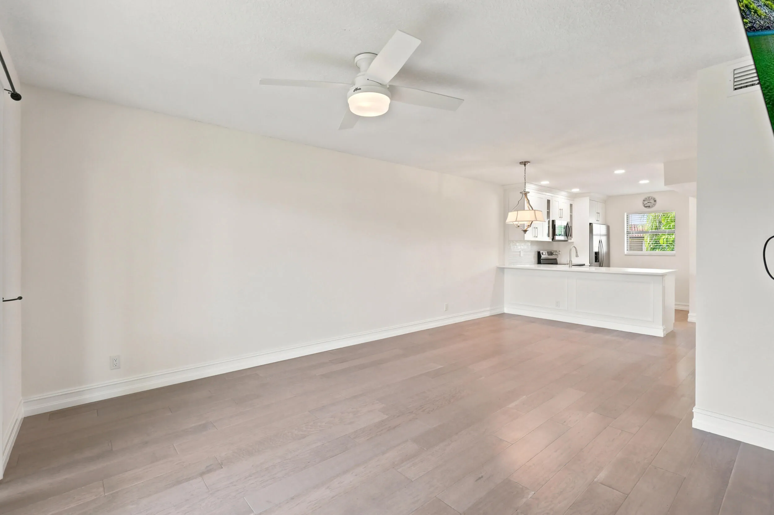 The spacious living area offers an open and versatile layout designed for comfortable everyday living and entertaining. Updated flooring flows throughout the space, while large sliding glass doors fill the room with natural light and provide seamless access to the private screened balcony. The open-concept design connects effortlessly to the kitchen and dining areas, creating a bright and inviting atmosphere throughout the home.
