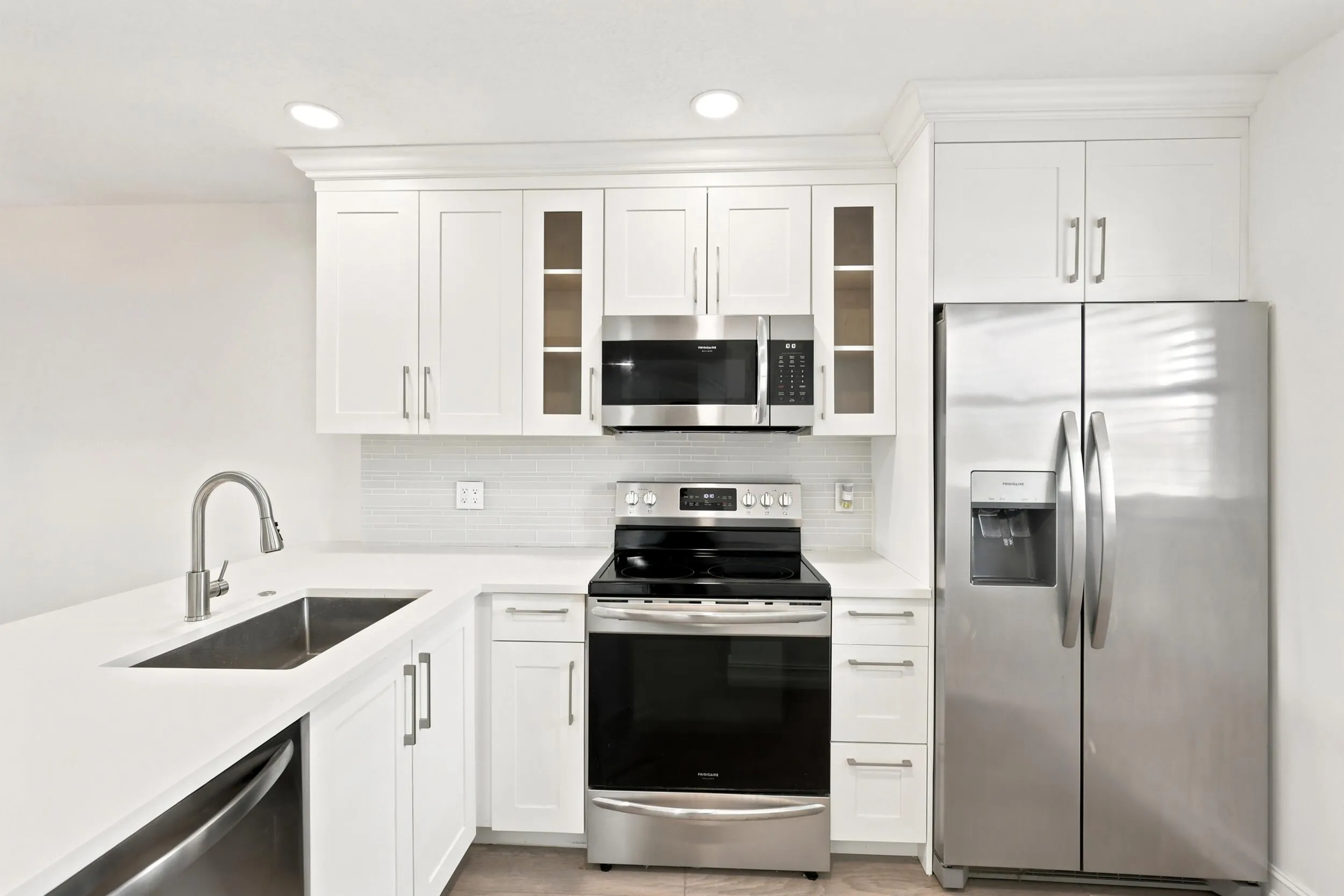 Beautifully updated with a clean, contemporary design, the kitchen features white shaker cabinetry, quartz countertops, stainless steel appliances, recessed lighting, and a stylish tile backsplash. The spacious peninsula provides additional seating and prep space while opening seamlessly to the main living area, creating an ideal layout for everyday living and entertaining. Thoughtful finishes and abundant storage complete this bright and functional centerpiece of the home.