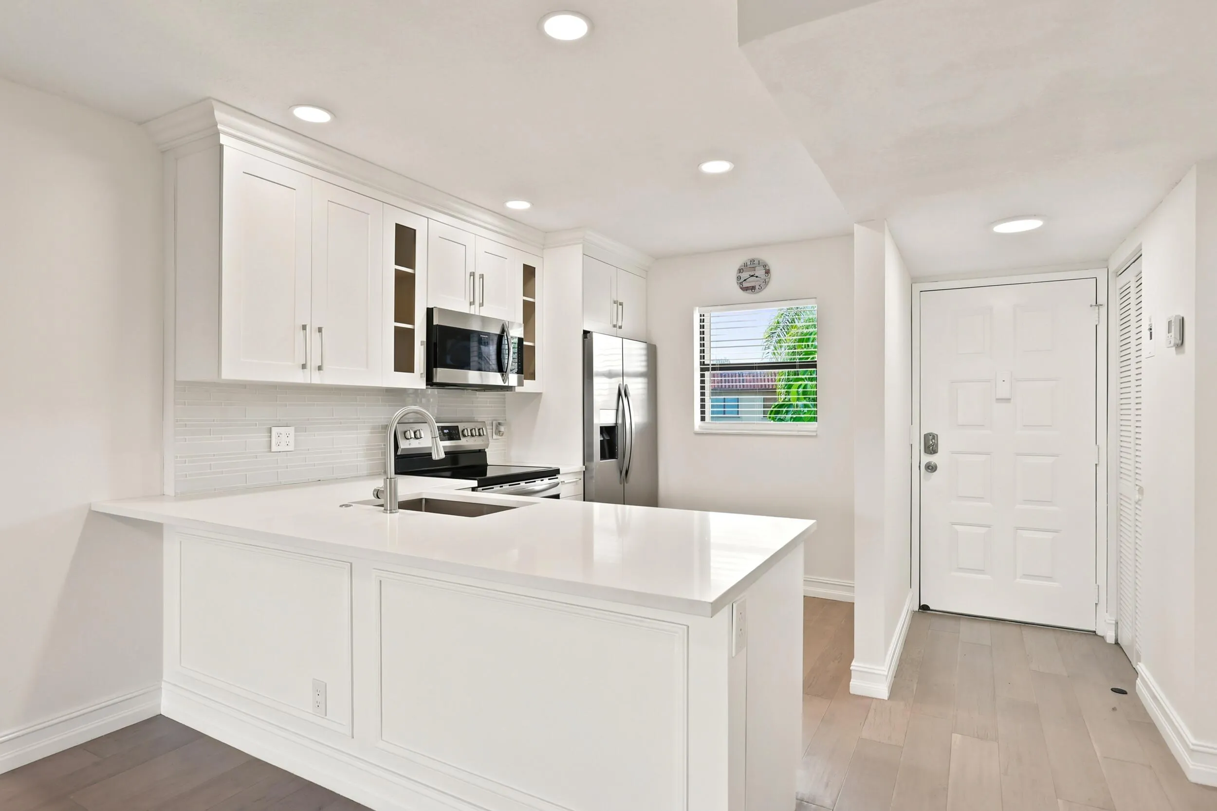 Beautifully updated with a clean, contemporary design, the kitchen features white shaker cabinetry, quartz countertops, stainless steel appliances, recessed lighting, and a stylish tile backsplash. The spacious peninsula provides additional seating and prep space while opening seamlessly to the main living area, creating an ideal layout for everyday living and entertaining. Thoughtful finishes and abundant storage complete this bright and functional centerpiece of the home.