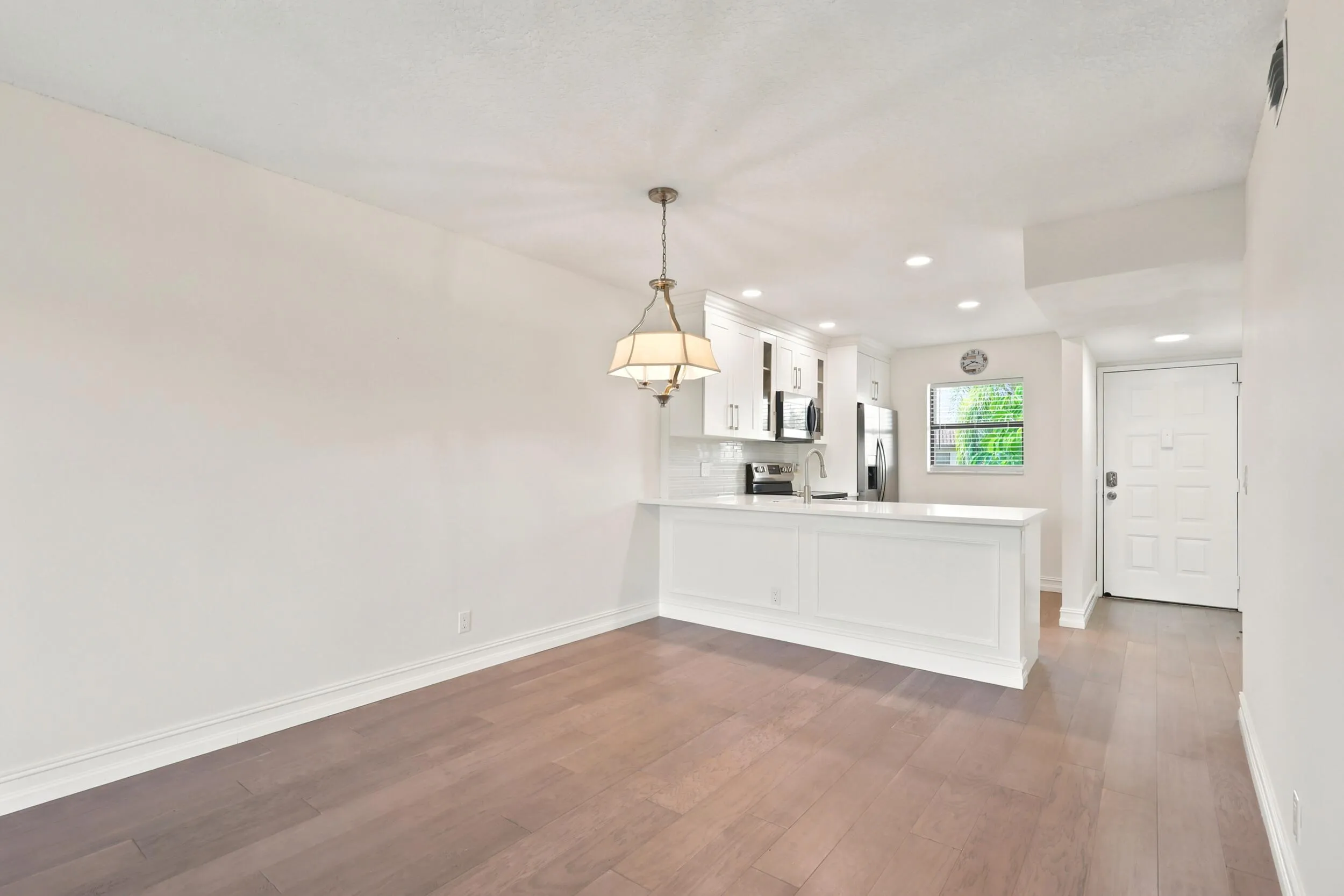 The spacious living area offers an open and versatile layout designed for comfortable everyday living and entertaining. Updated flooring flows throughout the space, while large sliding glass doors fill the room with natural light and provide seamless access to the private screened balcony. The open-concept design connects effortlessly to the kitchen and dining areas, creating a bright and inviting atmosphere throughout the home.