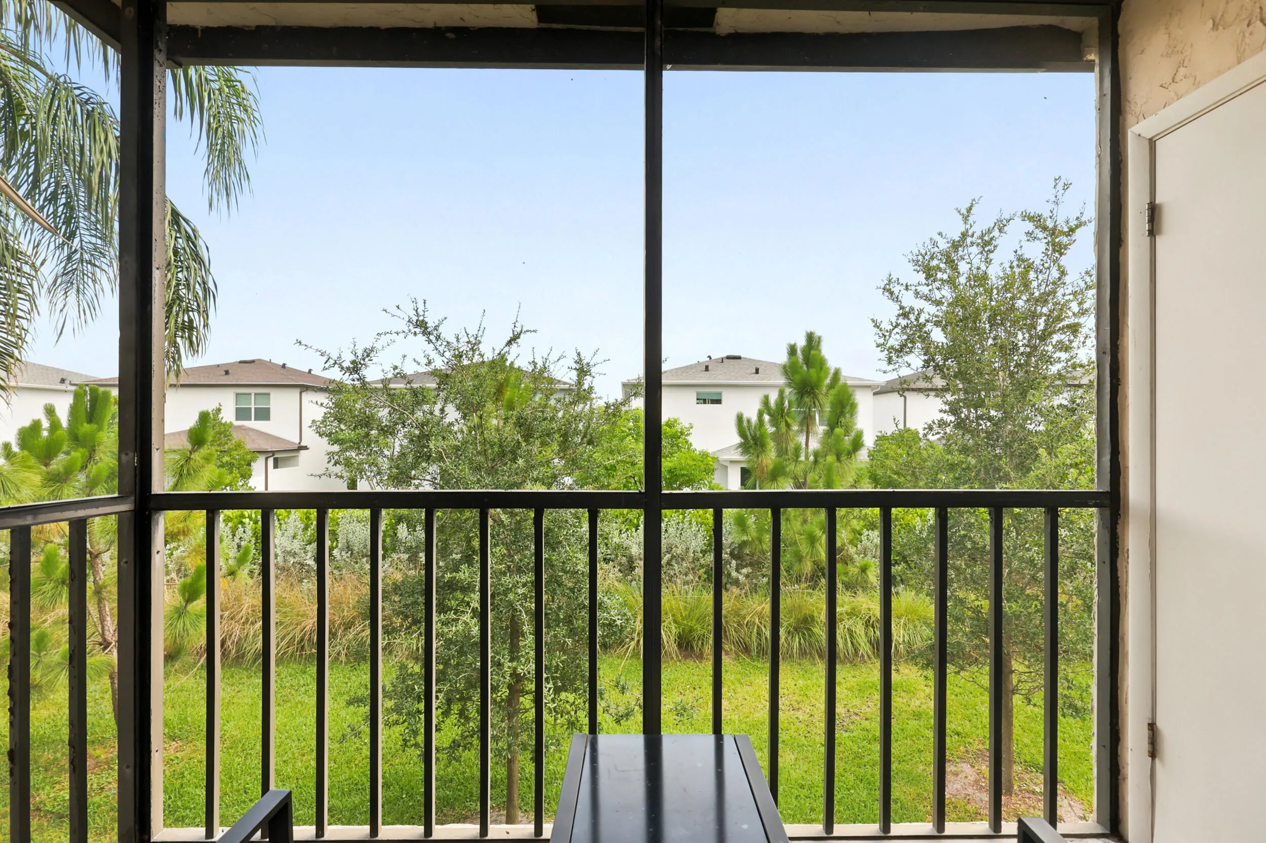 Enjoy your own private outdoor retreat from this screened balcony overlooking lush green space and mature tropical landscaping. Accessible directly from the living area, this inviting space is perfect for morning coffee, evening relaxation, or simply enjoying the peaceful surroundings and year-round South Florida weather. The screened enclosure provides added comfort while preserving the tranquil garden views below.