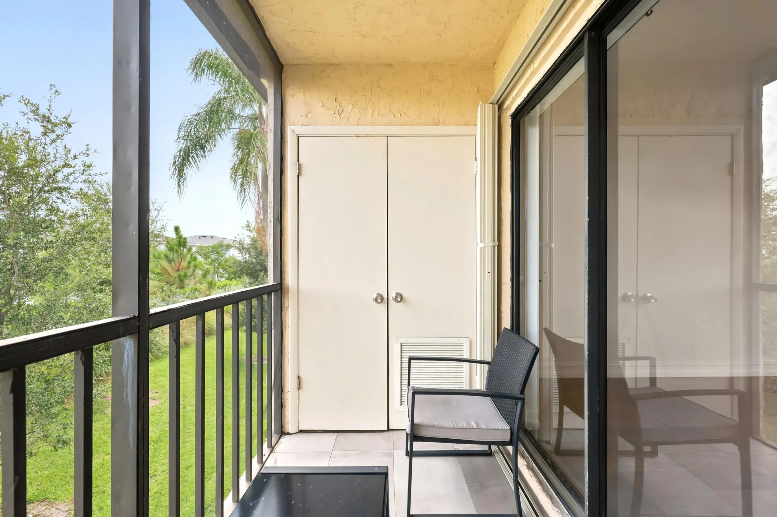 Enjoy your own private outdoor retreat from this screened balcony overlooking lush green space and mature tropical landscaping. Accessible directly from the living area, this inviting space is perfect for morning coffee, evening relaxation, or simply enjoying the peaceful surroundings and year-round South Florida weather. The screened enclosure provides added comfort while preserving the tranquil garden views below.