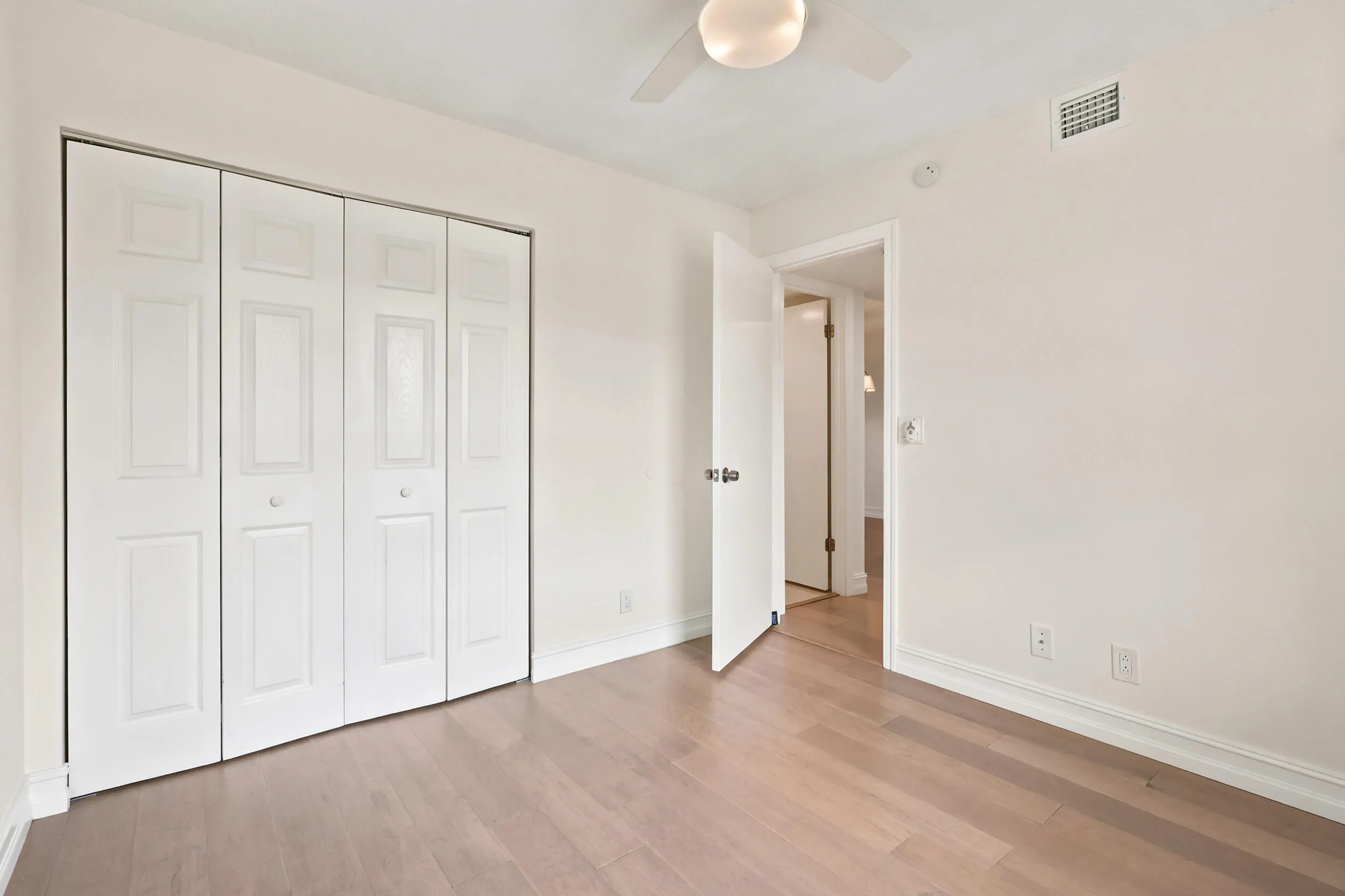 Bright and comfortable, the guest bedroom features updated flooring, generous closet space, and a large window that brings in plenty of natural light while overlooking the community's beautifully maintained grounds. The versatile layout is ideal for guests, a home office, or additional living space, offering both comfort and flexibility.