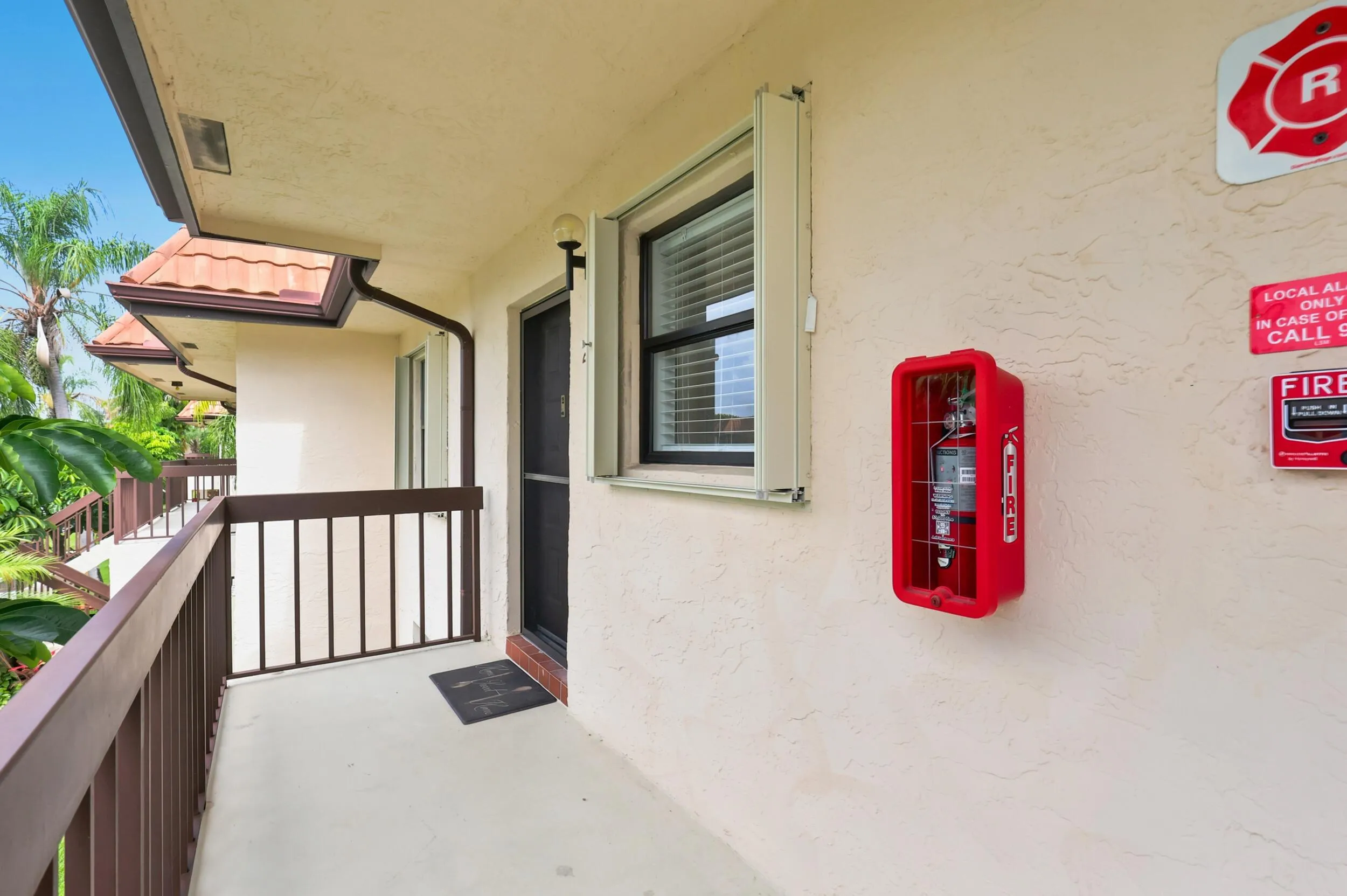 Arrive home through a covered second-floor entry offering added privacy and a welcoming approach. The exterior corridor is well maintained and conveniently located, providing easy access to the residence while overlooking the community's mature tropical landscaping and peaceful surroundings.