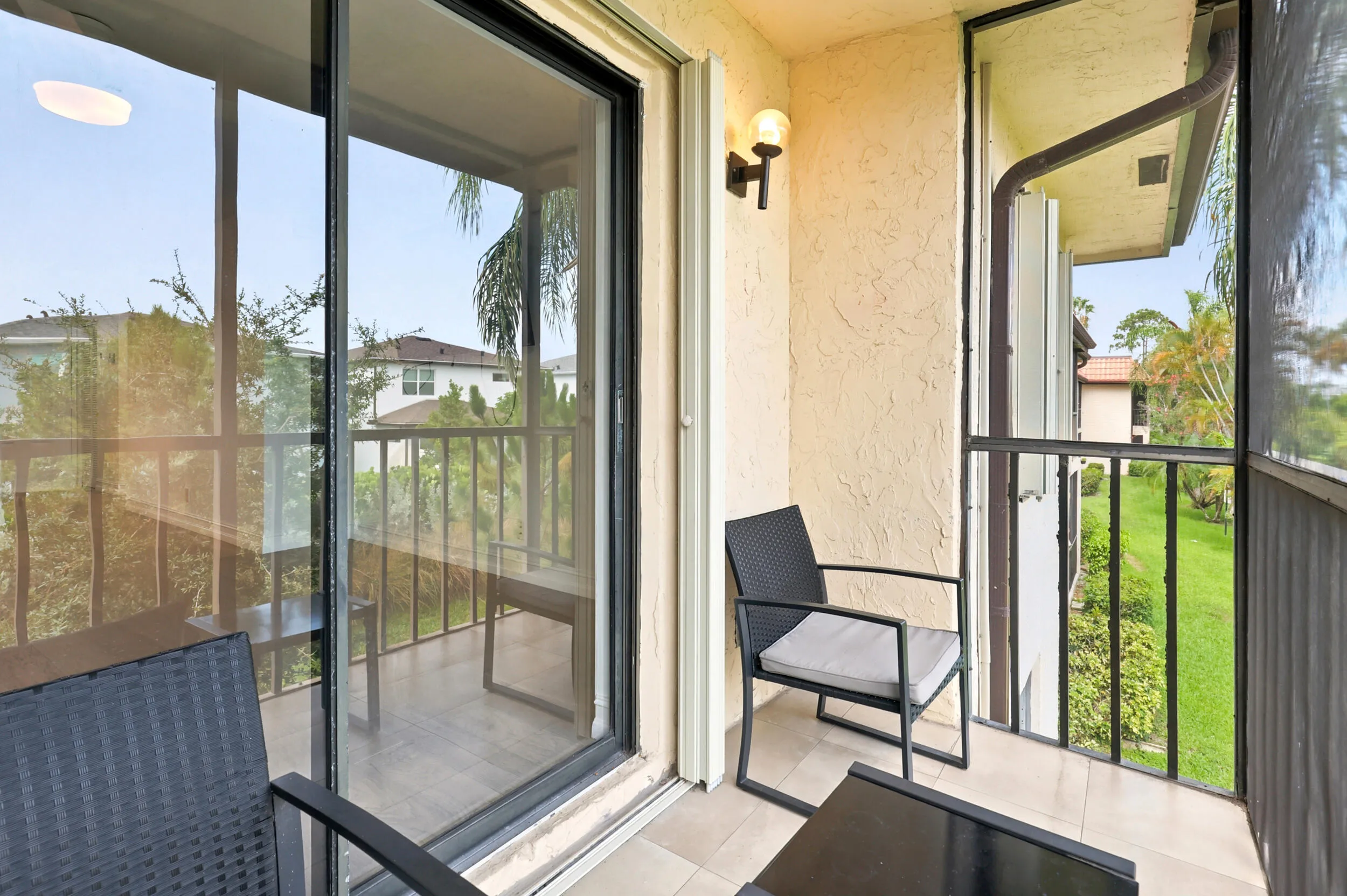 Enjoy your own private outdoor retreat from this screened balcony overlooking lush green space and mature tropical landscaping. Accessible directly from the living area, this inviting space is perfect for morning coffee, evening relaxation, or simply enjoying the peaceful surroundings and year-round South Florida weather. The screened enclosure provides added comfort while preserving the tranquil garden views below.