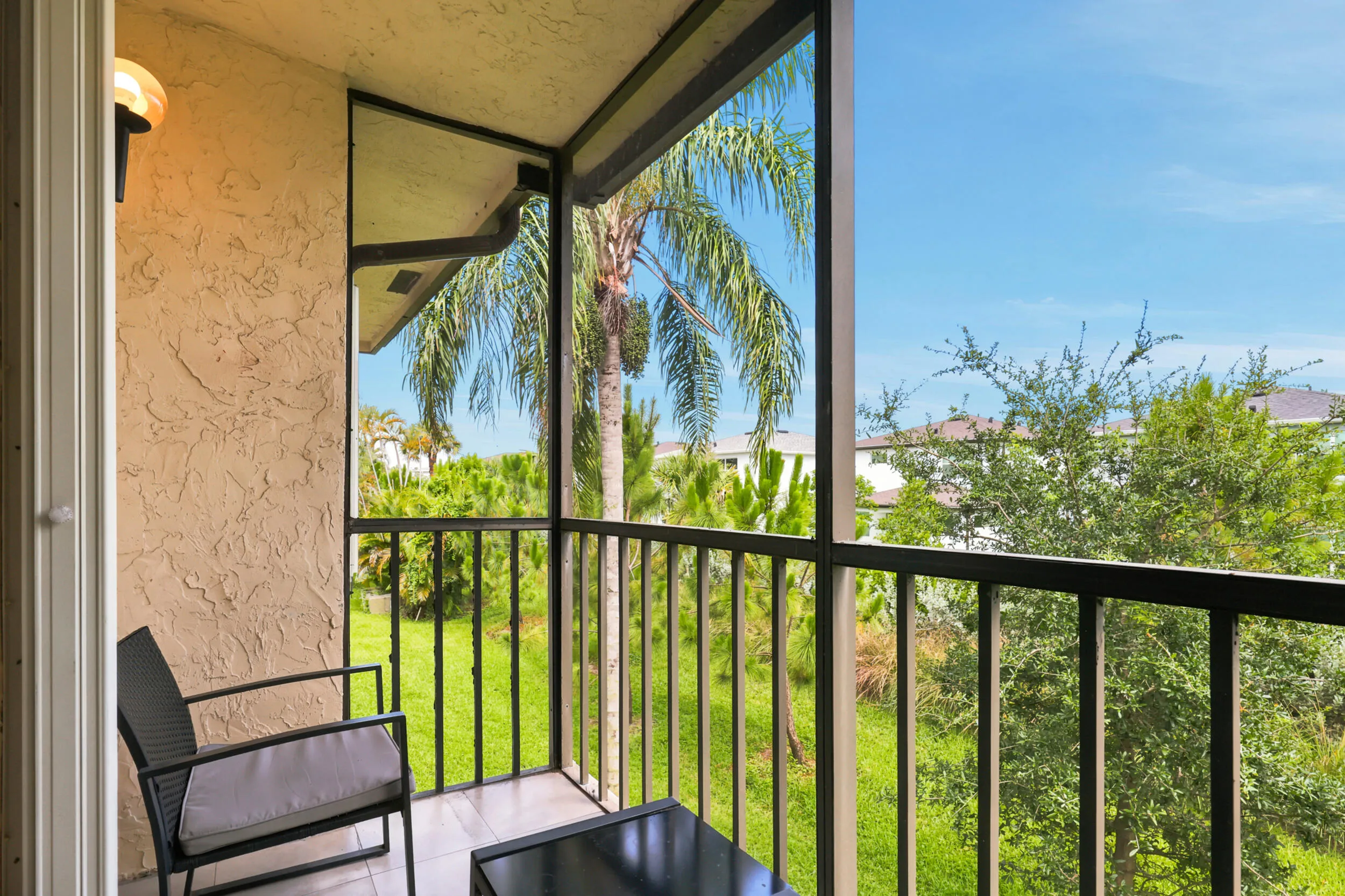 Enjoy your own private outdoor retreat from this screened balcony overlooking lush green space and mature tropical landscaping. Accessible directly from the living area, this inviting space is perfect for morning coffee, evening relaxation, or simply enjoying the peaceful surroundings and year-round South Florida weather. The screened enclosure provides added comfort while preserving the tranquil garden views below.