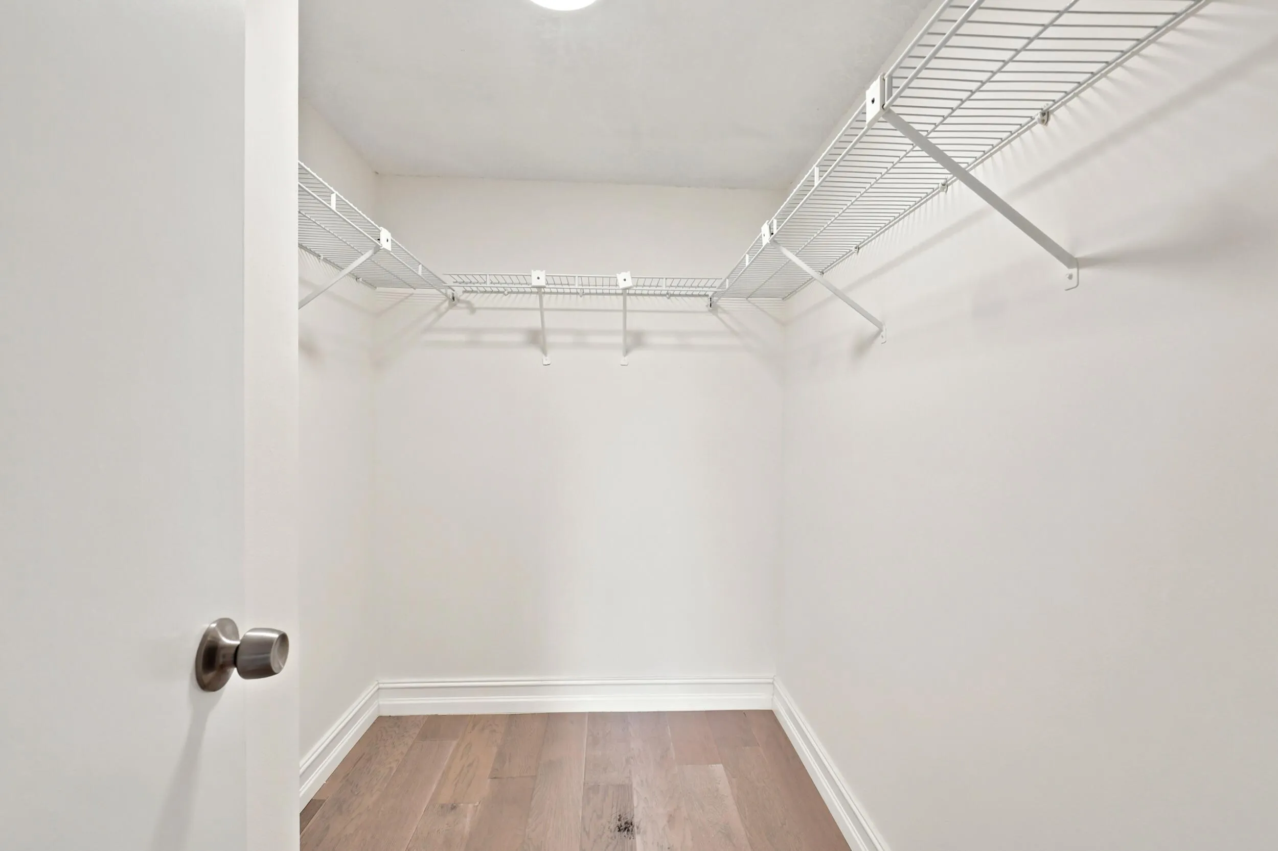 The spacious walk-in closet offers an abundance of storage with wraparound shelving and ample room for wardrobe organization. Designed for both functionality and convenience, it provides generous space to keep everything neatly organized and easily accessible.
