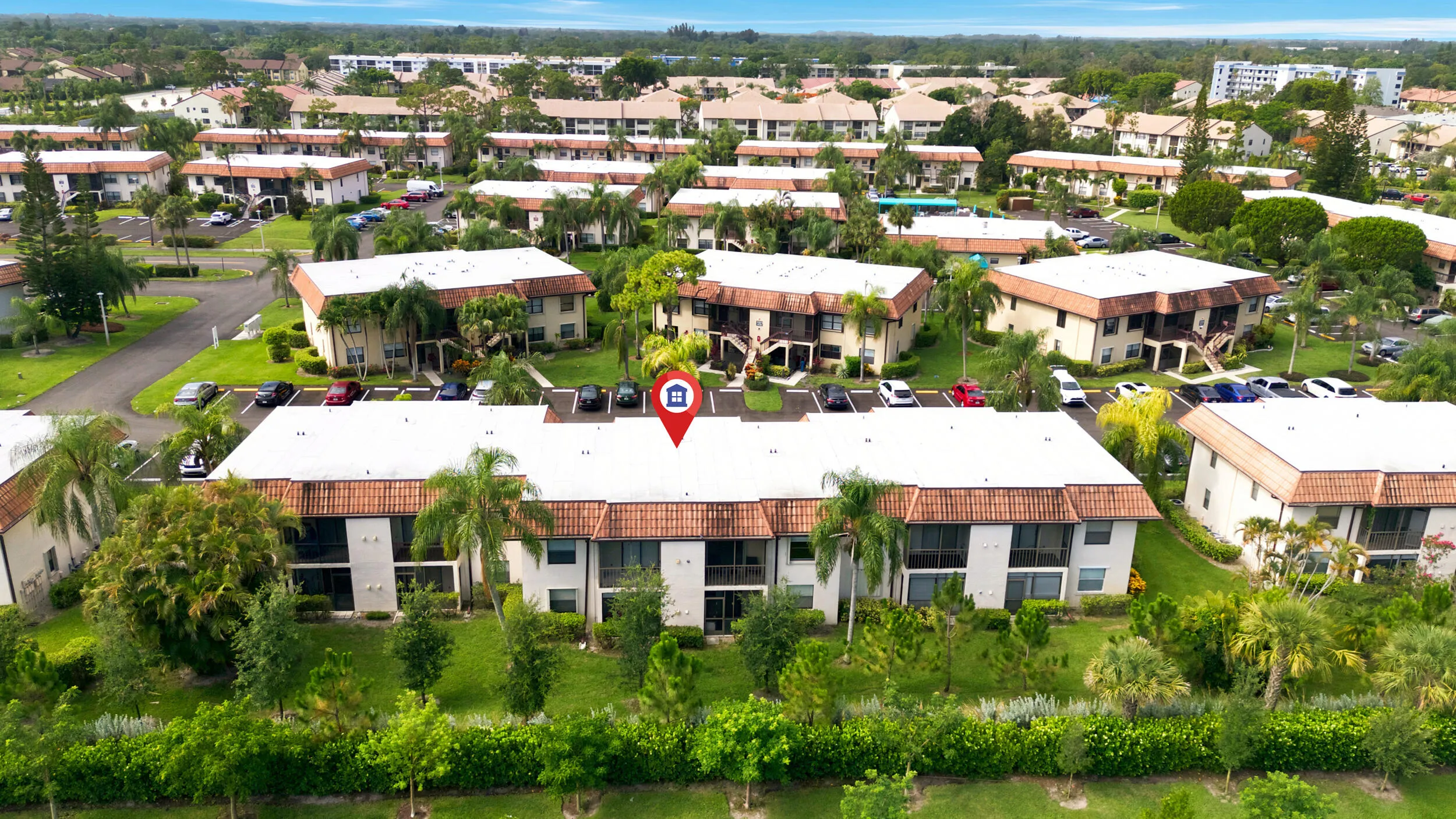 Enjoy a bird’s-eye perspective of this well-maintained community, showcasing the building's convenient location, abundant parking, mature tropical landscaping, and beautifully maintained grounds. Positioned within a peaceful residential setting, the property offers easy access to nearby shopping, dining, golf courses, parks, and major commuter routes while providing a tranquil place to call home.