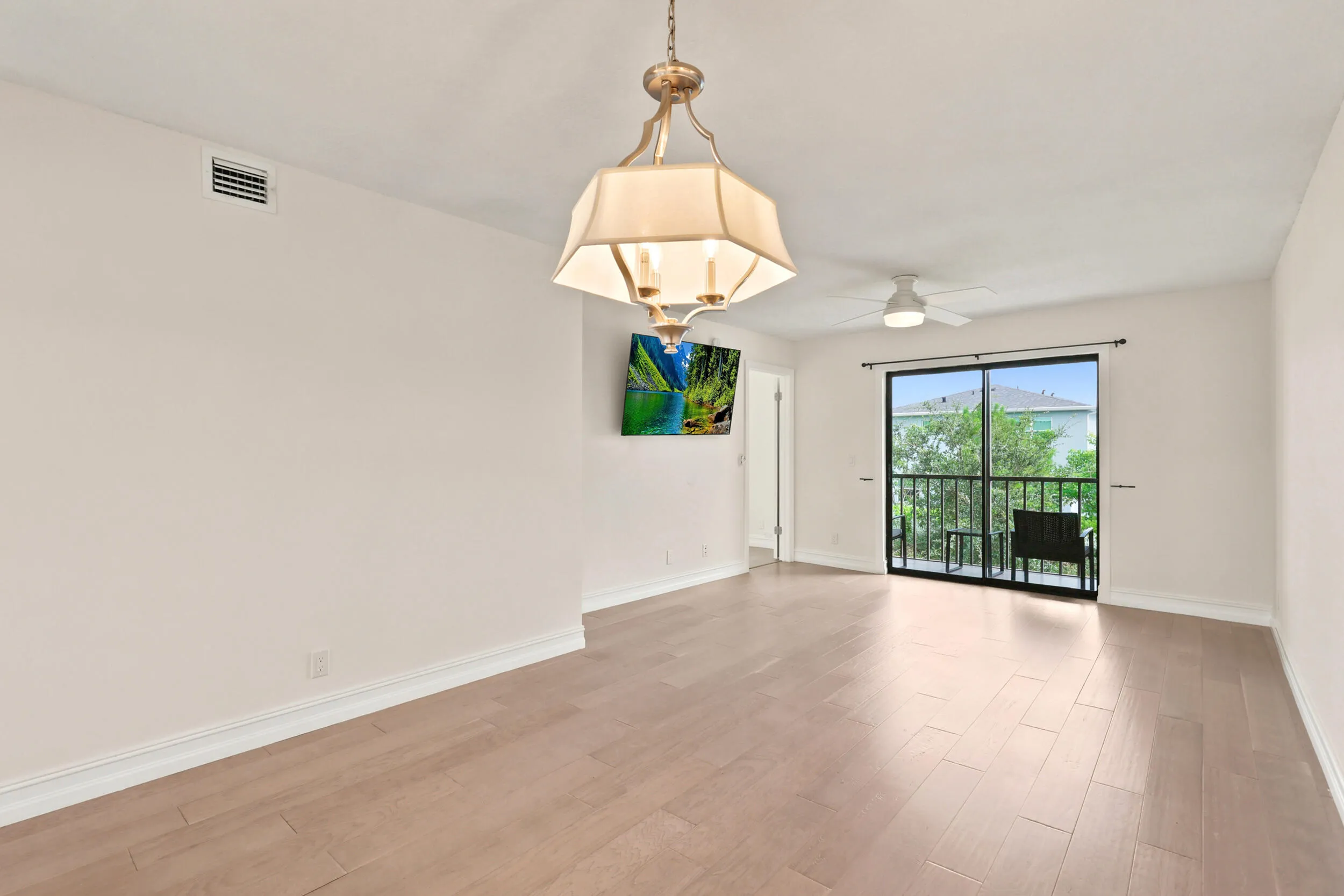 The spacious living area offers an open and versatile layout designed for comfortable everyday living and entertaining. Updated flooring flows throughout the space, while large sliding glass doors fill the room with natural light and provide seamless access to the private screened balcony. The open-concept design connects effortlessly to the kitchen and dining areas, creating a bright and inviting atmosphere throughout the home.
