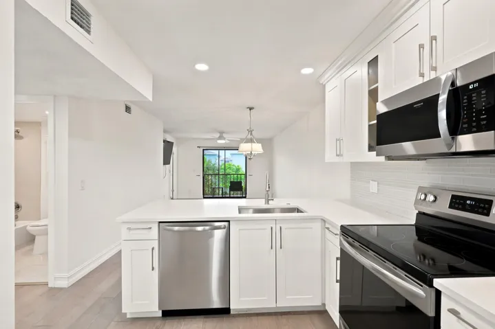 Beautifully updated with a clean, contemporary design, the kitchen features white shaker cabinetry, quartz countertops, stainless steel appliances, recessed lighting, and a stylish tile backsplash. The spacious peninsula provides additional seating and prep space while opening seamlessly to the main living area, creating an ideal layout for everyday living and entertaining. Thoughtful finishes and abundant storage complete this bright and functional centerpiece of the home.
