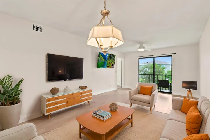 The spacious living area offers an open and versatile layout designed for comfortable everyday living and entertaining. Updated flooring flows throughout the space, while large sliding glass doors fill the room with natural light and provide seamless access to the private screened balcony. The open-concept design connects effortlessly to the kitchen and dining areas, creating a bright and inviting atmosphere throughout the home.