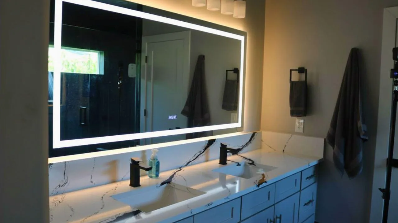 PRIMARY BATHROOM MIRRORSLighted anti-fog mirrors combine style and functionality, providing a modern luxury touch to the primary bath. Wilton Manors home for sale, heated saltwater pool, smart home, vacation rental, South Florida living, move-in ready home, pool home, luxury primary suite, chef's kitchen, energy-efficient home.