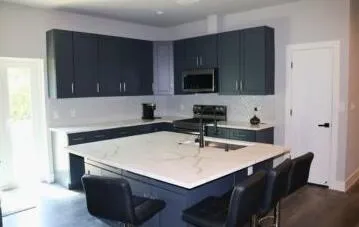 CHEF'S KITCHEN WITH ISLANDThe heart of the home features a chef-inspired kitchen with new appliances, a spacious dine-in island, and exceptional storage designed for both everyday living and entertaining. Wilton Manors home for sale, heated saltwater pool, smart home, vacation rental, South Florida living, move-in ready home, pool home, luxury primary suite, chef's kitchen, energy-efficient home.