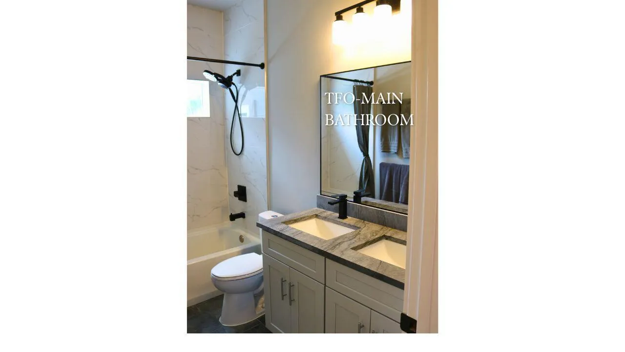 MAIN BATHROOM DOUBLE VANITYDouble sink vanity provides convenience and functionality while offering plenty of storage and counter space. Wilton Manors home for sale, heated saltwater pool, smart home, vacation rental, South Florida living, move-in ready home, pool home, luxury primary suite, chef's kitchen, energy-efficient home.