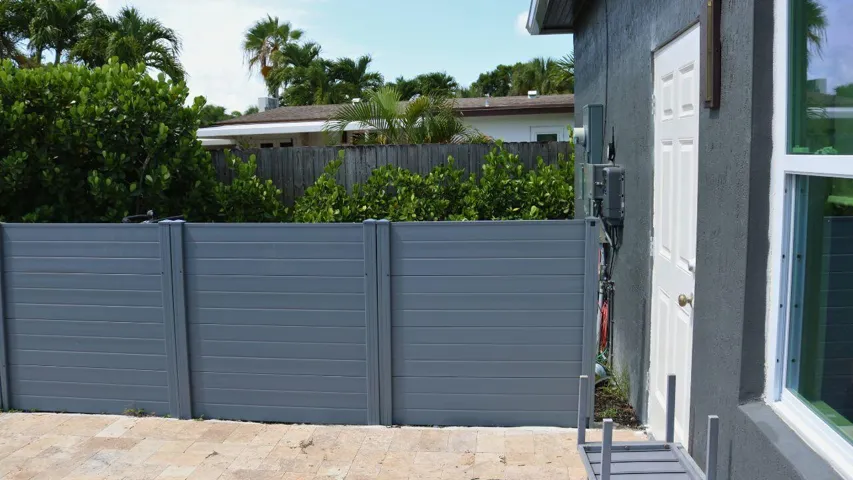 POOL EQUIPMENT AREAPool equipment is thoughtfully positioned behind a fenced enclosure, maintaining a clean and attractive backyard appearance. Wilton Manors home for sale, heated saltwater pool, smart home, vacation rental, South Florida living, move-in ready home, pool home, luxury primary suite, chef's kitchen, energy-efficient home.