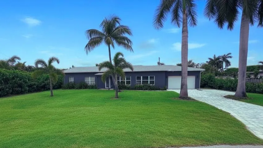 Beautiful Wilton Manors pool home with tropical landscaping, modern curb appeal, and a welcoming entrance that sets the tone for South Florida indoor-outdoor living. Wilton Manors home for sale, heated saltwater pool, smart home, vacation rental, South Florida living, move-in ready home, pool home, luxury primary suite, chef's kitchen, energy-efficient home.