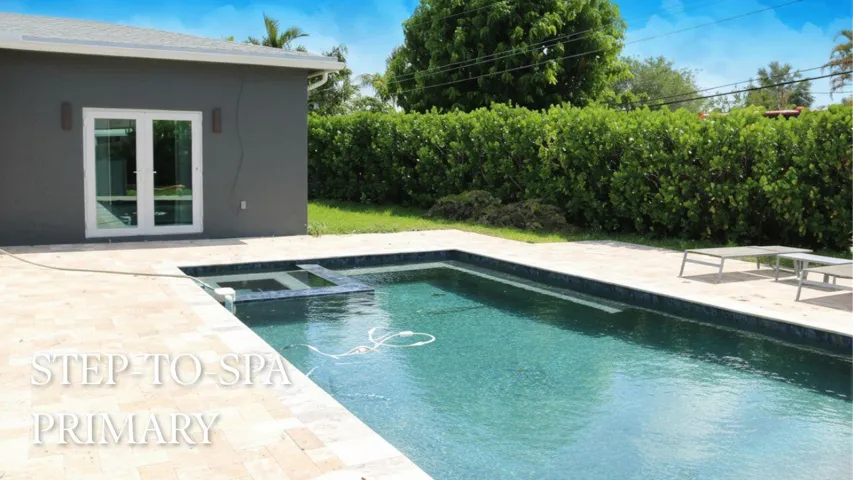 STEPS TO PRIMARY SUITE & HEATED SALTWATER POOLPrivate pathway from the primary suite leads directly to the heated saltwater pool, creating a true resort-style retreat right in your own backyard. Wilton Manors home for sale, heated saltwater pool, smart home, vacation rental, South Florida living, move-in ready home, pool home, luxury primary suite, chef's kitchen, energy-efficient home.
