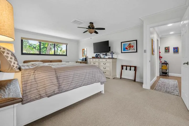 owner suite with ceiling fan and TV