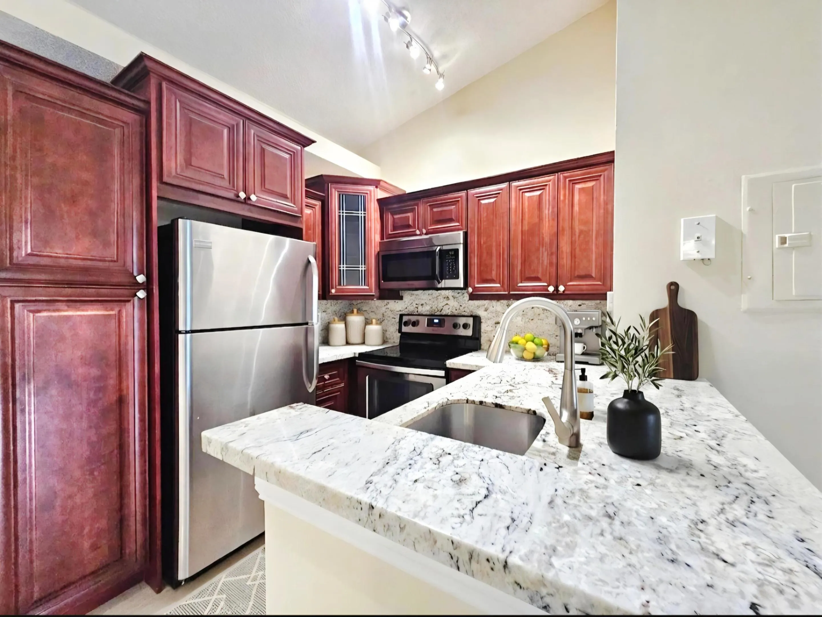 KITCHEN HAS CUSTOM CABINETRY, STAINLESS STEEL APPLIANCES AND GRANITE COUNTERTOPS