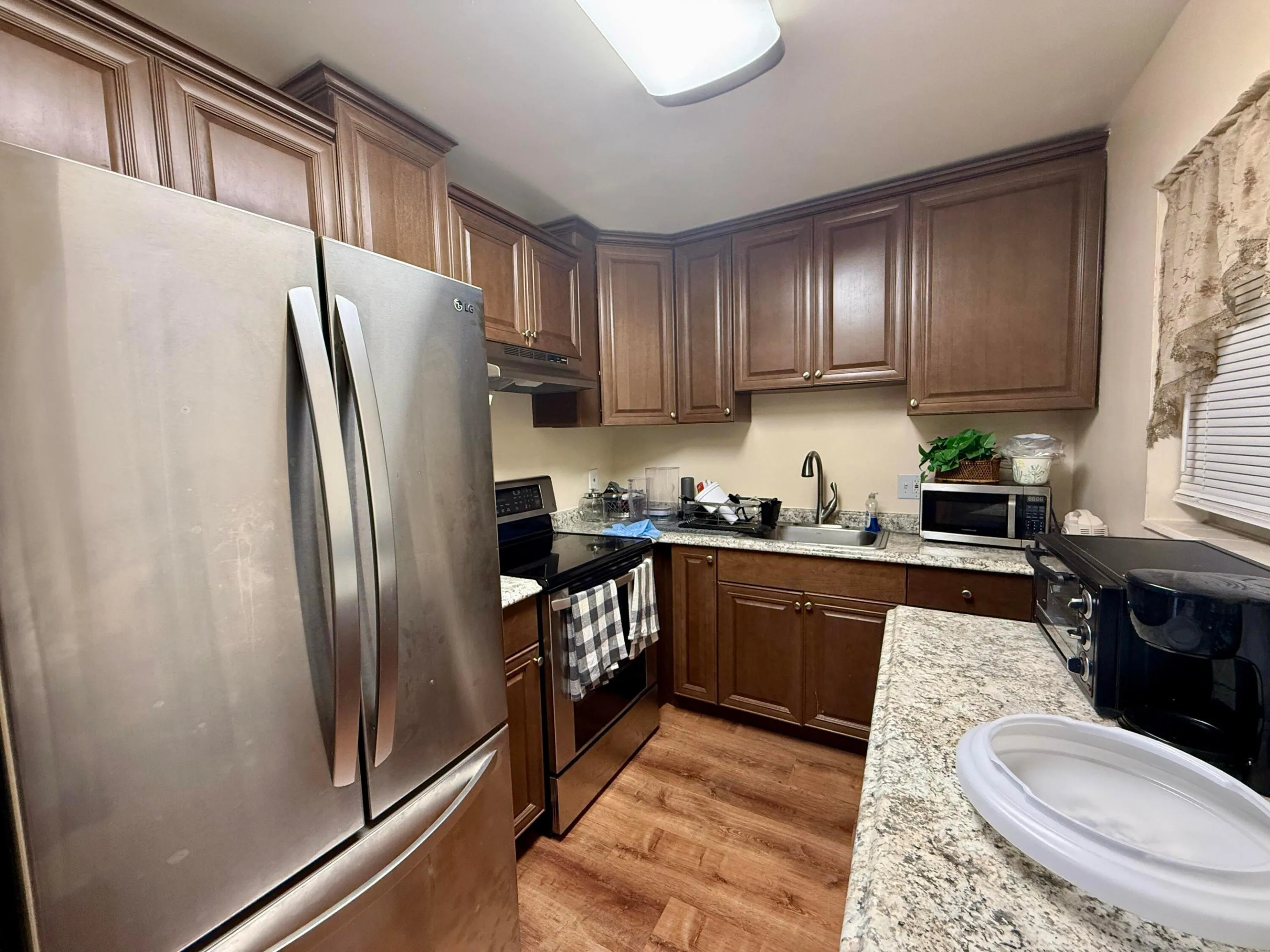 Pretty Updated Kitchen With Rich Wood Tone Cabinets, Stainless Appliances, and Window for Natural Light!
