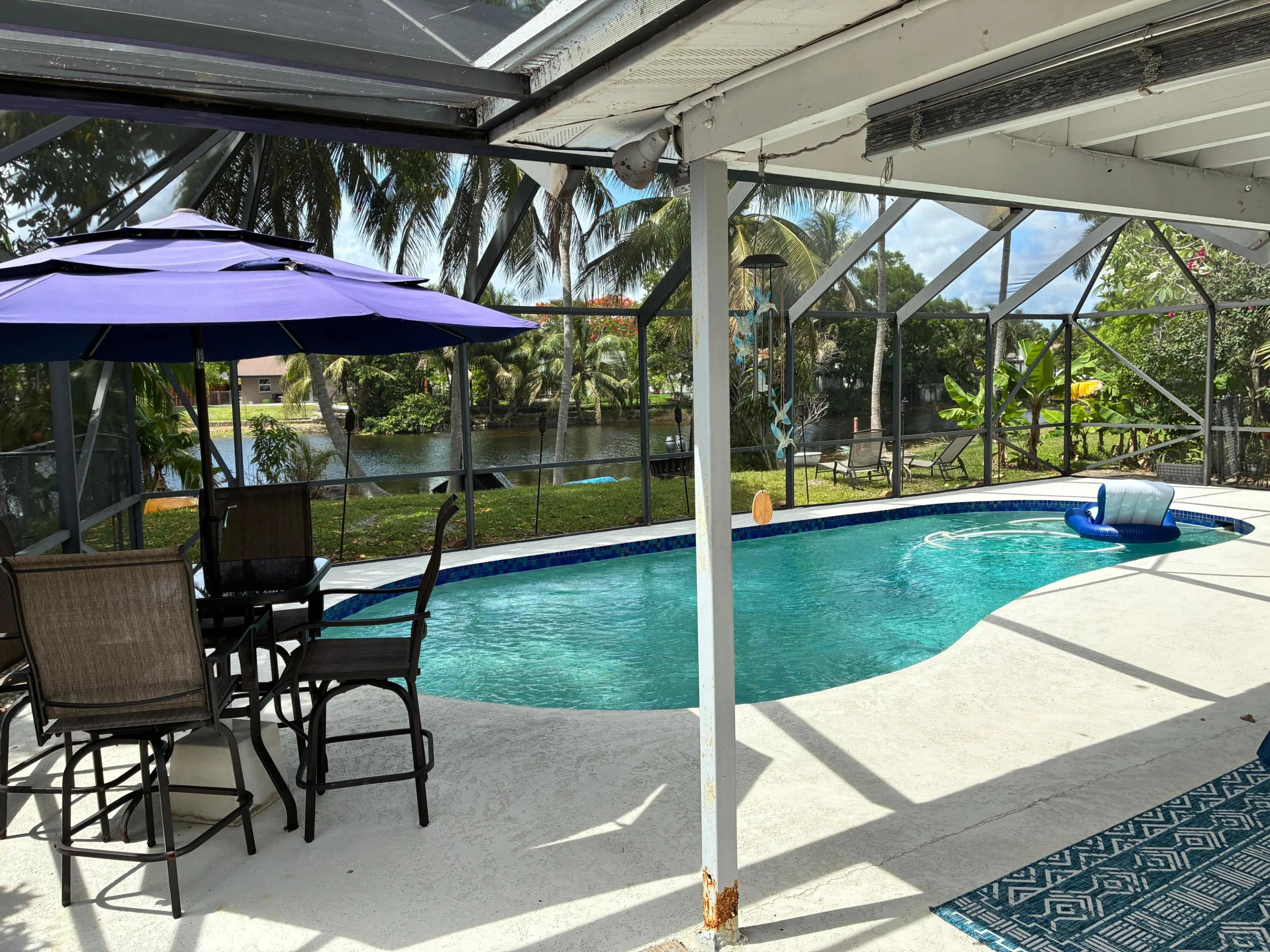 Screened patio and pool, with lounge chairs, accessible ftom dining room and master bedroom.
