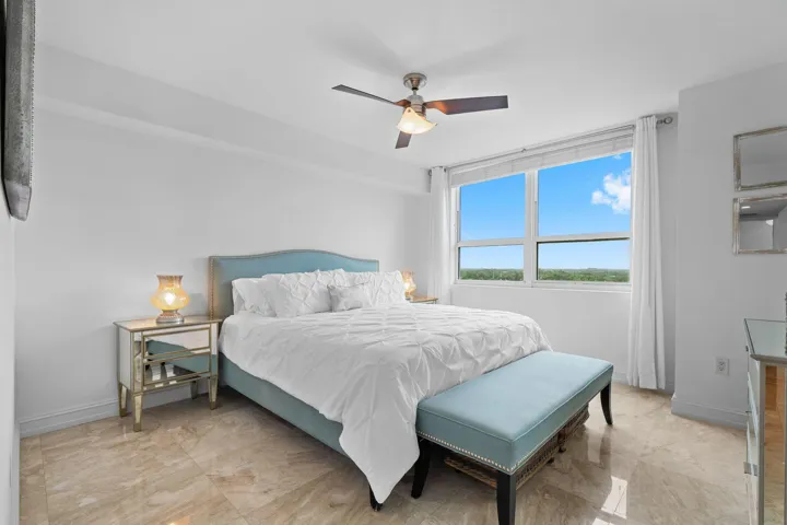 Generously sized primary bedroom with marble flooring, large windows, and tranquil views across Fort Lauderdale.