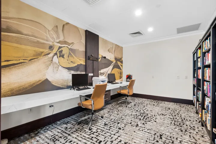 Resident business center with workstations, built-in shelving, and practical space for remote work or printing needs.