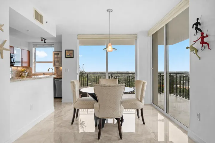 Dining area set beside sliding glass doors, creating a seamless indoor-outdoor connection to the wraparound terrace.