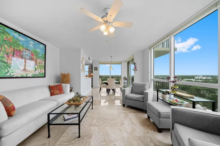 Spacious living room with marble flooring, expansive glass, and direct access to the covered wraparound terrace.