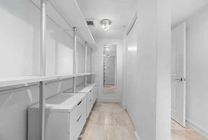 Large walk-in closet with built-in shelving, hanging space, and drawer storage for organized everyday living.