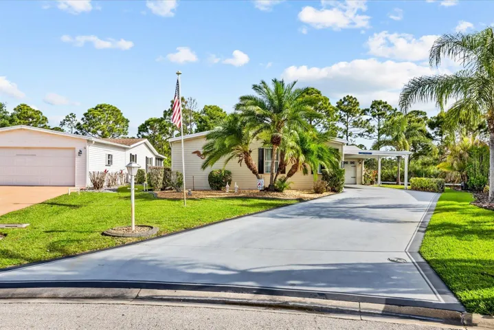 Oversized driveway with covered carport and garage
