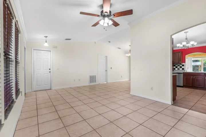 Living room facing garage door and primary bedroom on other side