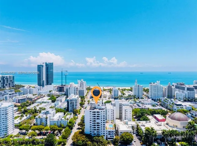 High-rise residential building featuring a swimming pool, balcony levels, and proximity to the coastline