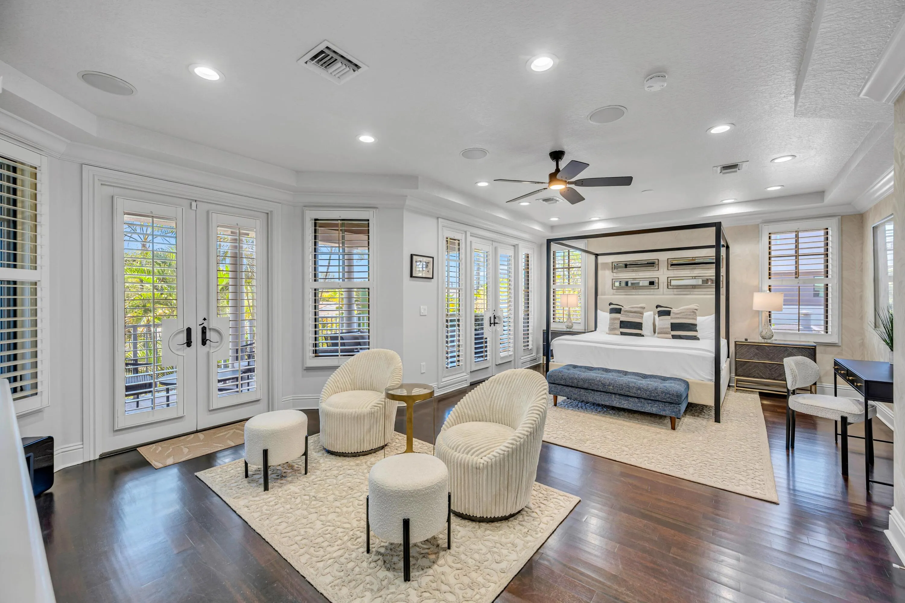 Primary bedroom with seating area. French doors leading out to expansive covered patio.
